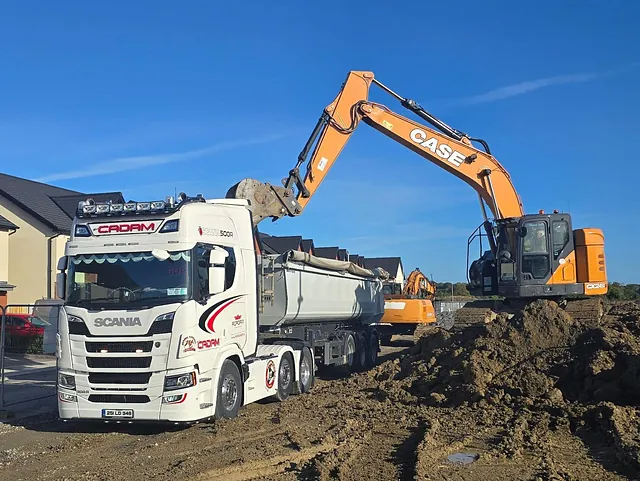 Digger dumping gravel into a dumper